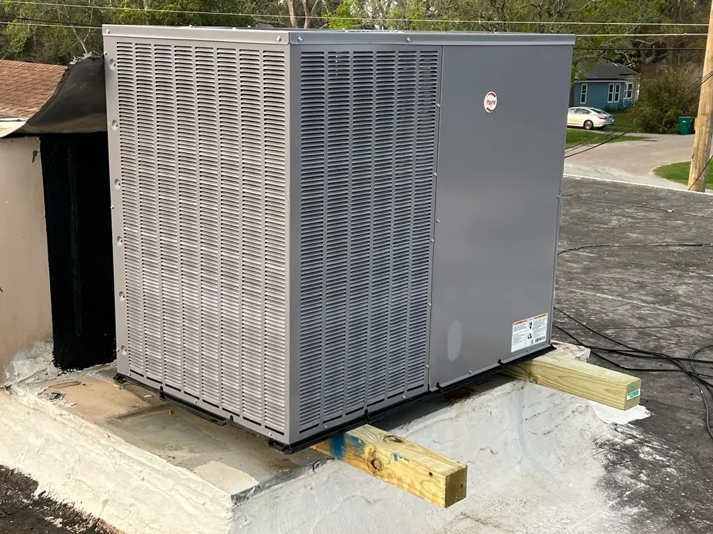 Packaged rooftop unit installed on timber sleepers over a flat roof in the Houston area